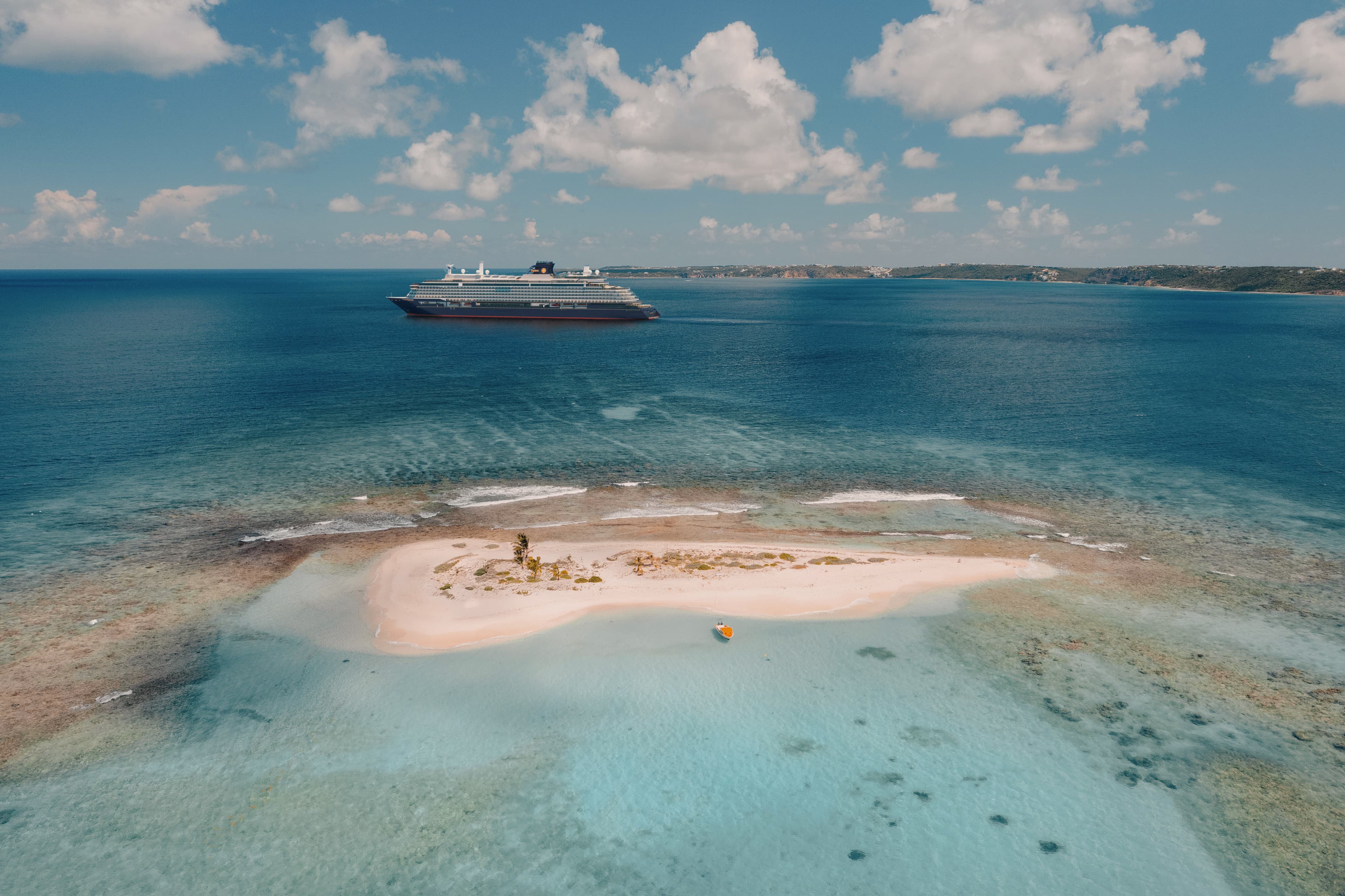 Explora Journeys ship anchored off a remote Caribbean sandbar island with turquoise water