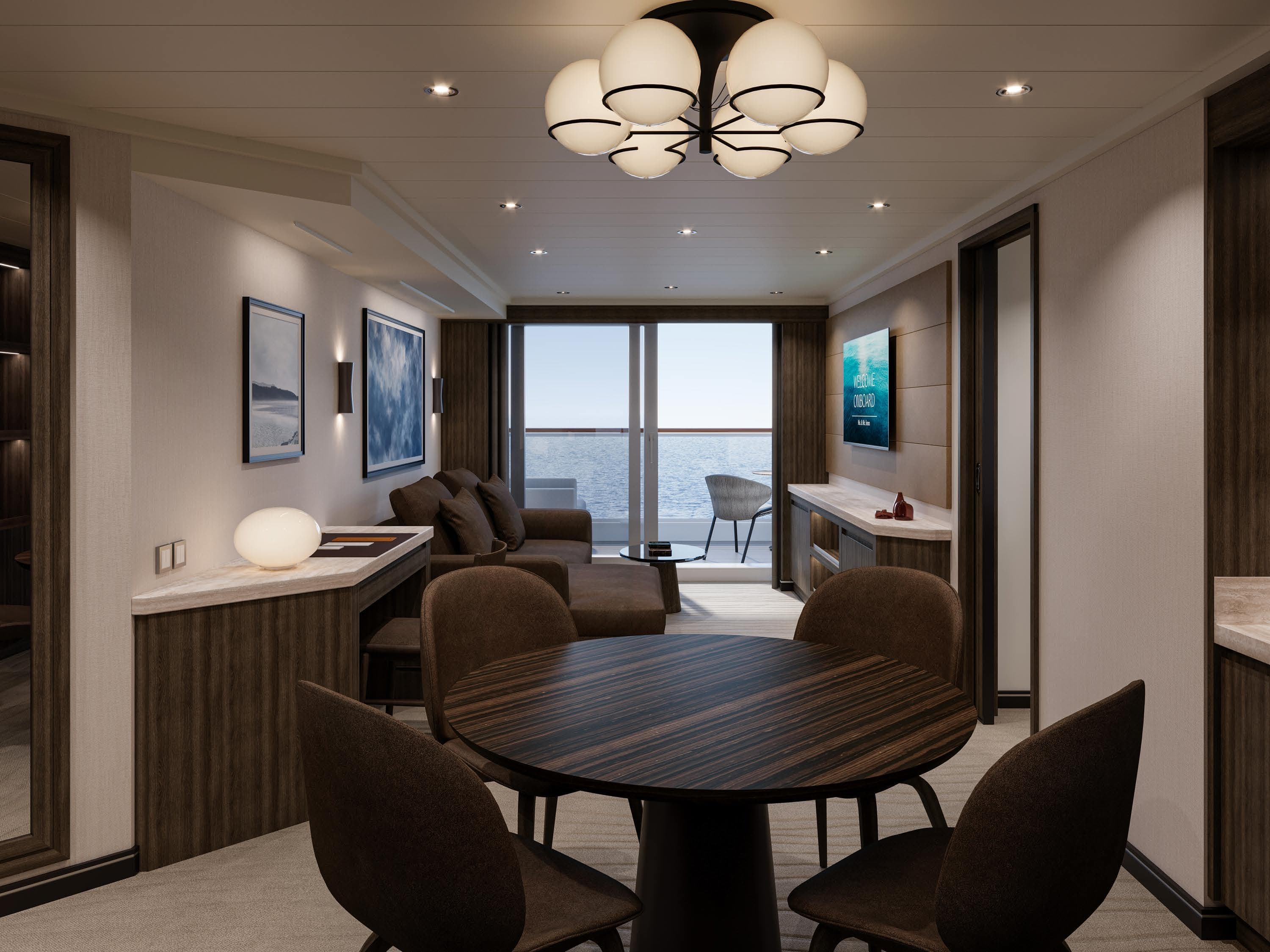 Elegantly furnished Explora Journeys ocean suite with a private terrace balcony overlooking the sea, featuring warm wood tones and modern decor